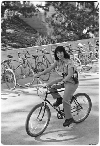 Campus police officer checking bicycles in front of Geisel Library