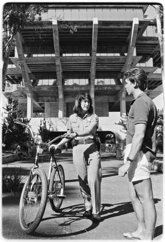 Campus police officer checking bicycles in front of Geisel Library