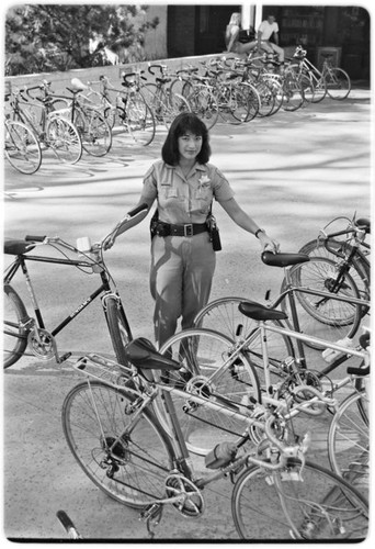 Campus police officer checking bicycles in front of Geisel Library