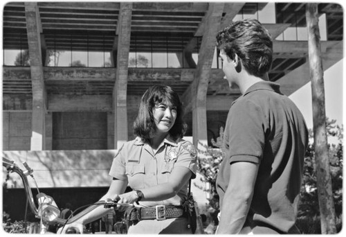 Campus police officer checking bicycles in front of Geisel Library