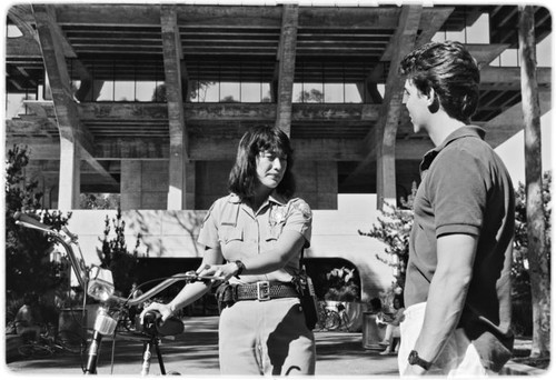 Campus police officer checking bicycles in front of Geisel Library