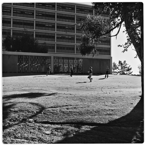 Students playing football on lawn outside Urey Hall