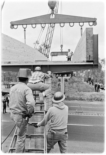 Pedestrian footbridge over U.S. Highway 101 hoisted into place by two cranes