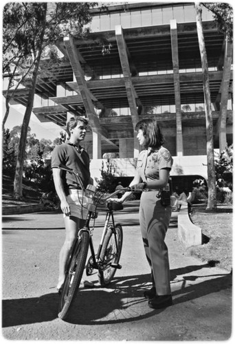 Campus police officer checking bicycles in front of Geisel Library