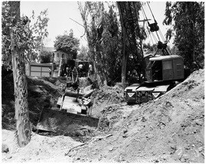 Crane overturned trying to pull stuck tractor at Guardia and Huntington Drive North, 1958