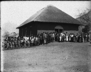 African people standing in front of a building with a thatched roof, Shilouvane, South Africa