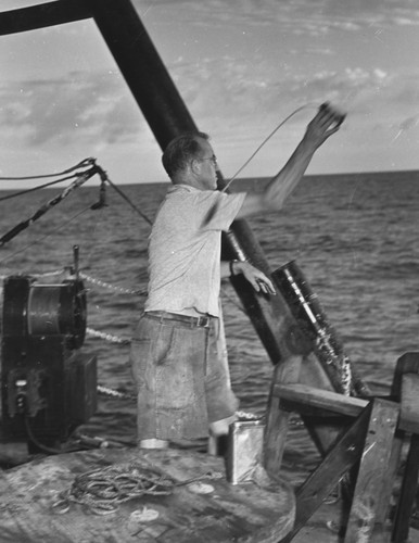Russell W. Raitt throws a TNT charge into the ocean from R/V Spencer F. Baird