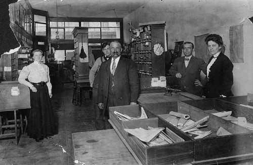John W. Duckworth, Anaheim Postmaster, and postal employees inside post office building [graphic]