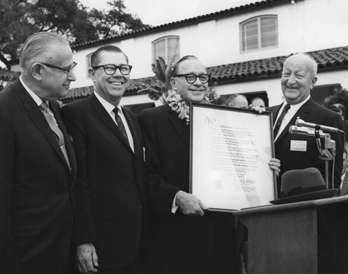 Jack Benny Displaying a Proclamation Declaring Him an Honorary Citizen of Anaheim. [graphic]