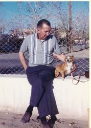 Barney Allen Cogsdell seated with his dog on concrete wall, about 1965