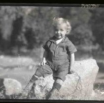 Child sitting on a rock