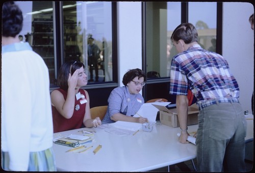 Freshmen at Welcome Day registration tables in front of Galbraith Hall