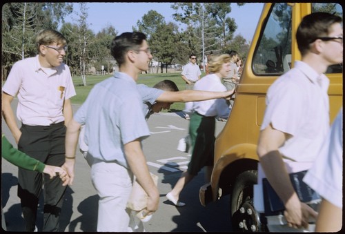 Students walking beside UCSD school bus