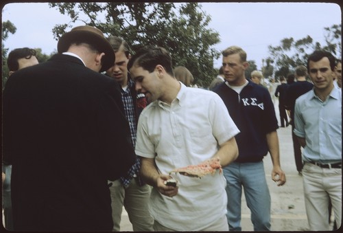 Students and a staff member gather to measure the watermelon splat in the first annual watermelon drop