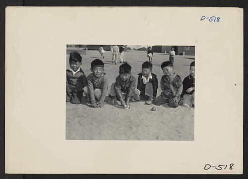 These youngsters are playing in the field of a nursery school at Manzanar, a War Relocation Authority Center where evacuees of Japanese ancestry will spend the duration. Photographer: Stewart, Francis Manzanar, California