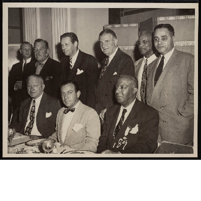 Group photograph with standing (left-right): unidentified man, Maurice Tobin, James J. Lyons, Ashley L. Totten, Ralph Bunche, seated (left-right): unidentified man, Robert Wagner, A. Philip Randolph