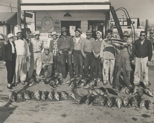Fishing group with Sam Hennig holding jackpot catch, Newport Beach, ca. 1947