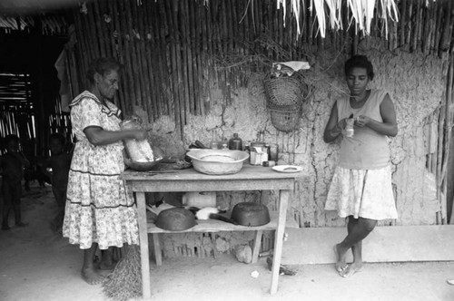 Two women cooking in front of a table, San Basilio de Palenque, 1976