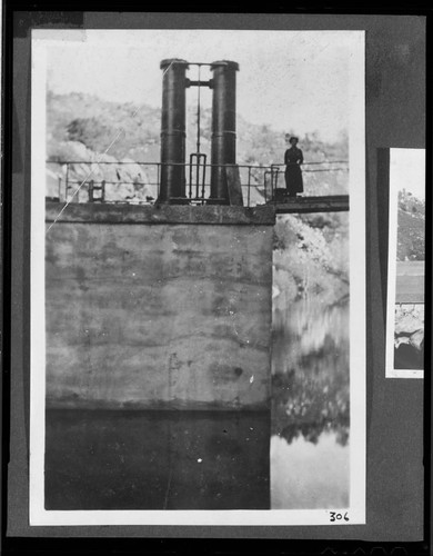 A woman standing by the hydraulic gate lifters on Democrat dam for Kern River #1 Hydro Plant
