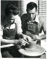 Two men working at a potter's wheel