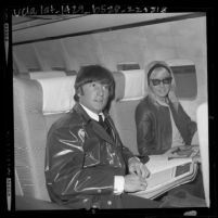 John Lennon and wife Cynthia sitting in airplane on stop over in Los Angeles, Calif., 1964