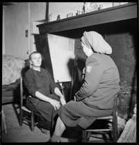 [Angers: Thérèse Bonney speaking to older woman, seated by her kitchen fireplace]