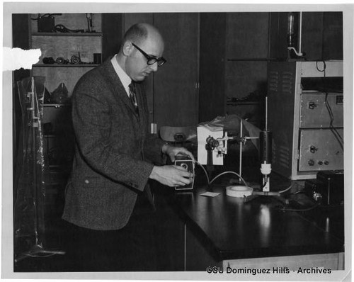 Physics Professor Dr. Robert Alt demonstrating lab equipment