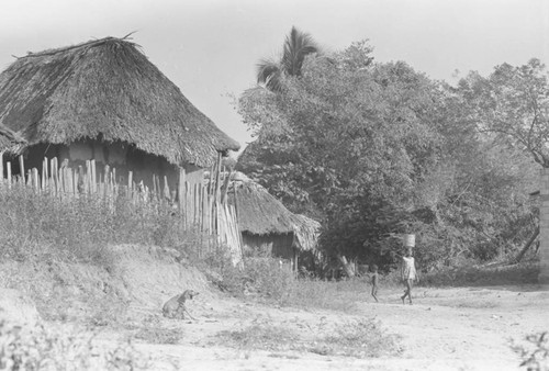 Girl walking with metal bucket on her head, San Basilio de Palenque, 1976