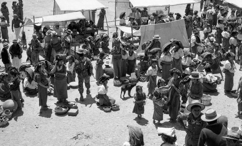 Mayan women, men, and children and soldiers at the market in Chajul, Chajul, 1982
