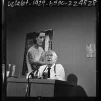 Upton Sinclair talking to reporters about photographic exhibit, "The Bitter Years: 1935-1941," Los Angeles, 1964