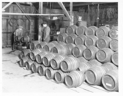 Brewing Industry - Stockton: Beer kegs in pile on factory floor, probably Valley Brewing Co., two unidentified men, 617 N. Stanislaus St