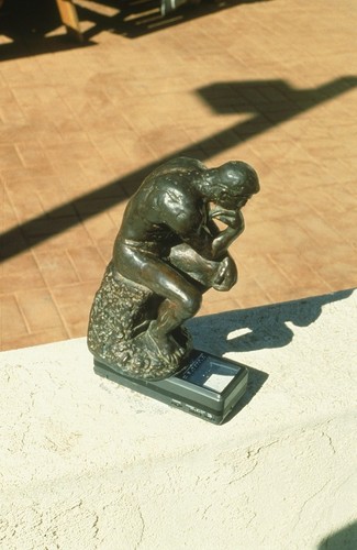 Something Pacific: detail: bronze figurine of Rodin's "The Thinker" on top of miniature portable television