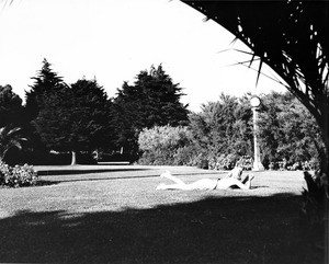 A woman laying in the grass in a park