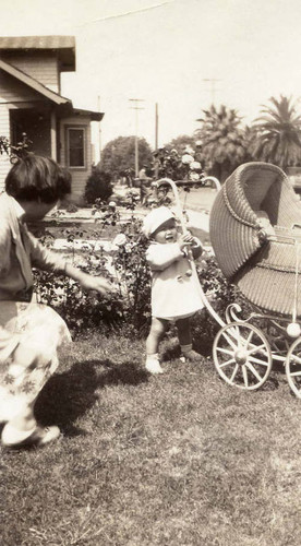 One year old Ronald Siu holding on to his baby carriage