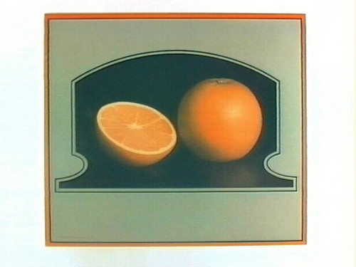 Stock label: orange and orange half on dark surface in tombstone-shaped frame