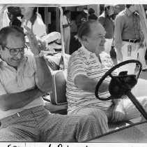 Bob Hope, the legendary comedian and movie and TV star, driving a cart with developer and philanthropist Alex Spanos beside him