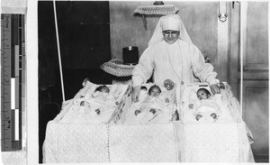 Sr. Marquette, MM, with triplets at St. Paul's Hospital, Manila, Philippines, 1935