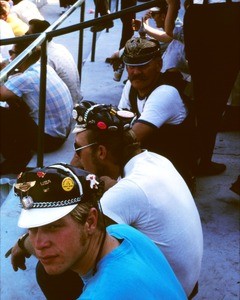 Men sitting in stadium with decorated caps