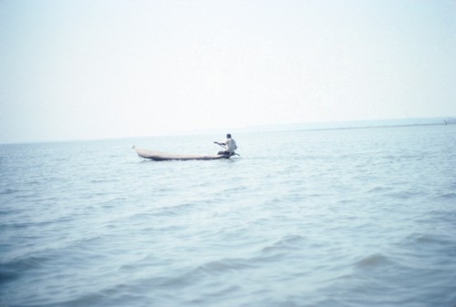Fisherman paddling out to check his nets on Lake Mweru Wantipa, Kaputa District