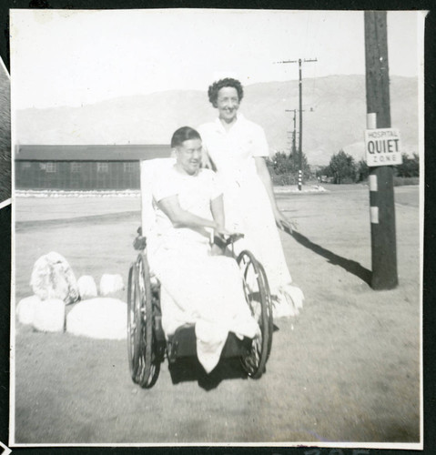 Photograph of Peter Hondo in a wheelchair with Thelma McBride at Manzanar