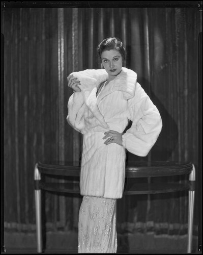 Actress Gail Patrick modeling a white Russian ermine coat, 1932