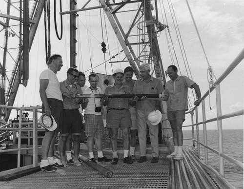 Oil Core from sigsbee Knolls-Scientific staff of Leg I of the Deep Sea Drilling Project, are holding the oil-bearing core from the Challenger Knoll. Left to right: Dr. W.A. Berggren, Woods Hole Oceanographic Institution; Dr. Emile A. Pessagno, Jr., Oil Corporation, Ponca City, Oka.; Dr. David Bukry, U.S. Geological Survey, La Jolla, California; Dr. J. Lamar Worzel, Associate Director, Lamont-Doherty Geological Observatory, Columbia University; Technician Steve Ivey, Scripps Institution of Oceanography, La Jolla, Calif.; Dr. Maruice Ewing, Director, Lamont-Doherty Geological Observatory, Colubia University and Dr. Creighton Burk, Mobile Oil Corp., New York city. First leg scientists, Dr. Alfred G. Fischer, of Princton University was not present when the photograph was taken. Dr. Ewing and Dr. Worzel were Cruise Co-Chief Scientists on Leg I - Orange, Texas to New York City