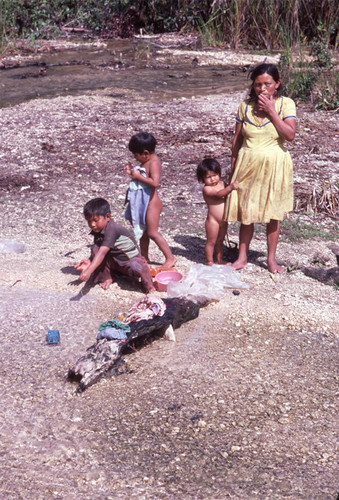 Guatemalan refugees wash their clothes at a river, Cuauhtémoc, 1983