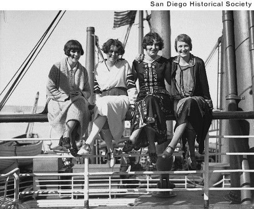 Four women sitting on a railing aboard the SS Manchuria