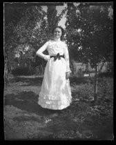 Young woman in white dress, with dark bow around her waist