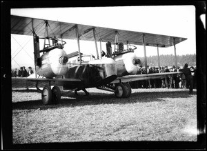 Crowd of people around a large twin-engine biplane