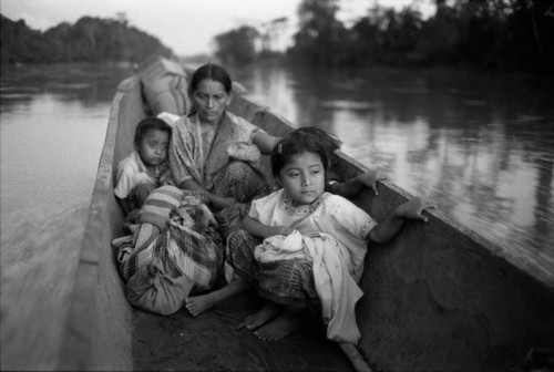 Refugee woman and three children in a canoe, Chiapas, 1983