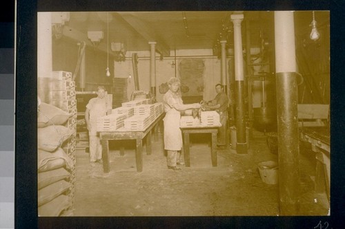 [Factory workers at tables.]