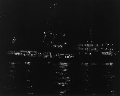 Research ship D/V Glomar Challenger (ship) as seen at night during operations off the west coast of Mexico during Leg 66 of the Deep Sea Drilling Project. 1979
