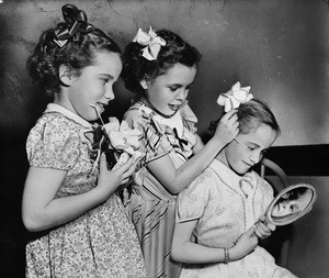 Three little girls of the Los Angeles Orphanage with hair ribbons, 1948